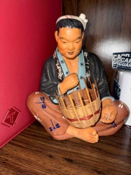 Seated Ceramic Figure with Woven Basket