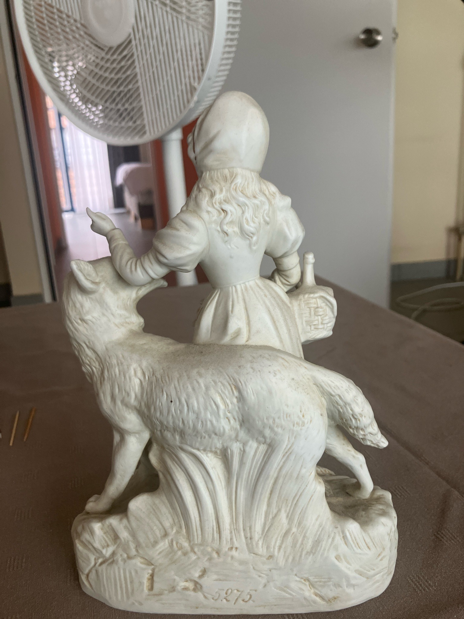 Submitted photo of Bisque porcelain figural group featuring a young girl and a wolf