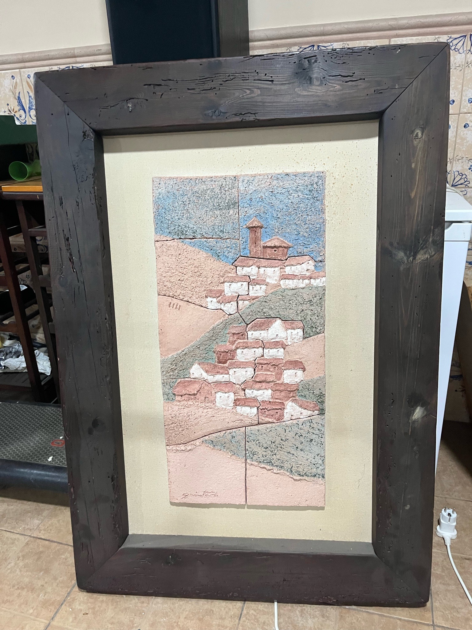 Submitted photo of Mixed media tile art depicting a hillside village, signed indistinctly (unauthenticated)