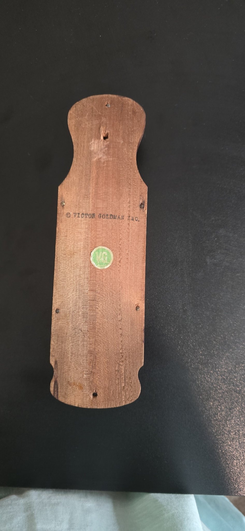 Submitted photo of Wooden wall-mounted plaque or holder, bearing a stamp reading 'VICTOR GOLDMAN INC.'