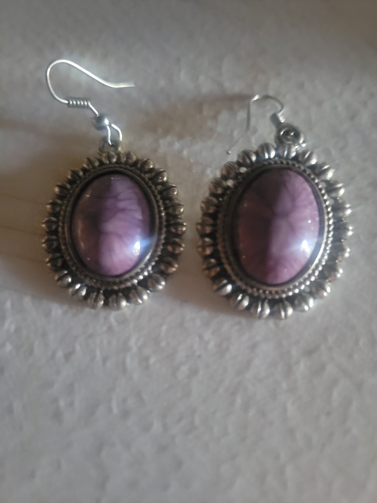 Submitted photo of Silver-toned dangling earrings with purple cabochons