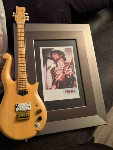Prince-Themed Display with Miniature Guitar and Framed Photo