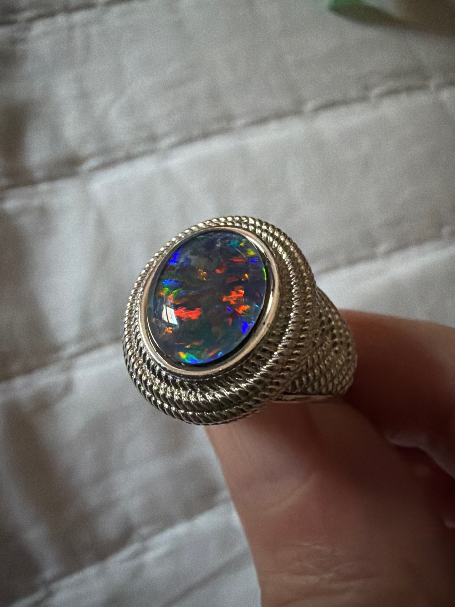 Submitted photo of Ring with an opal-style gemstone and textured metal band