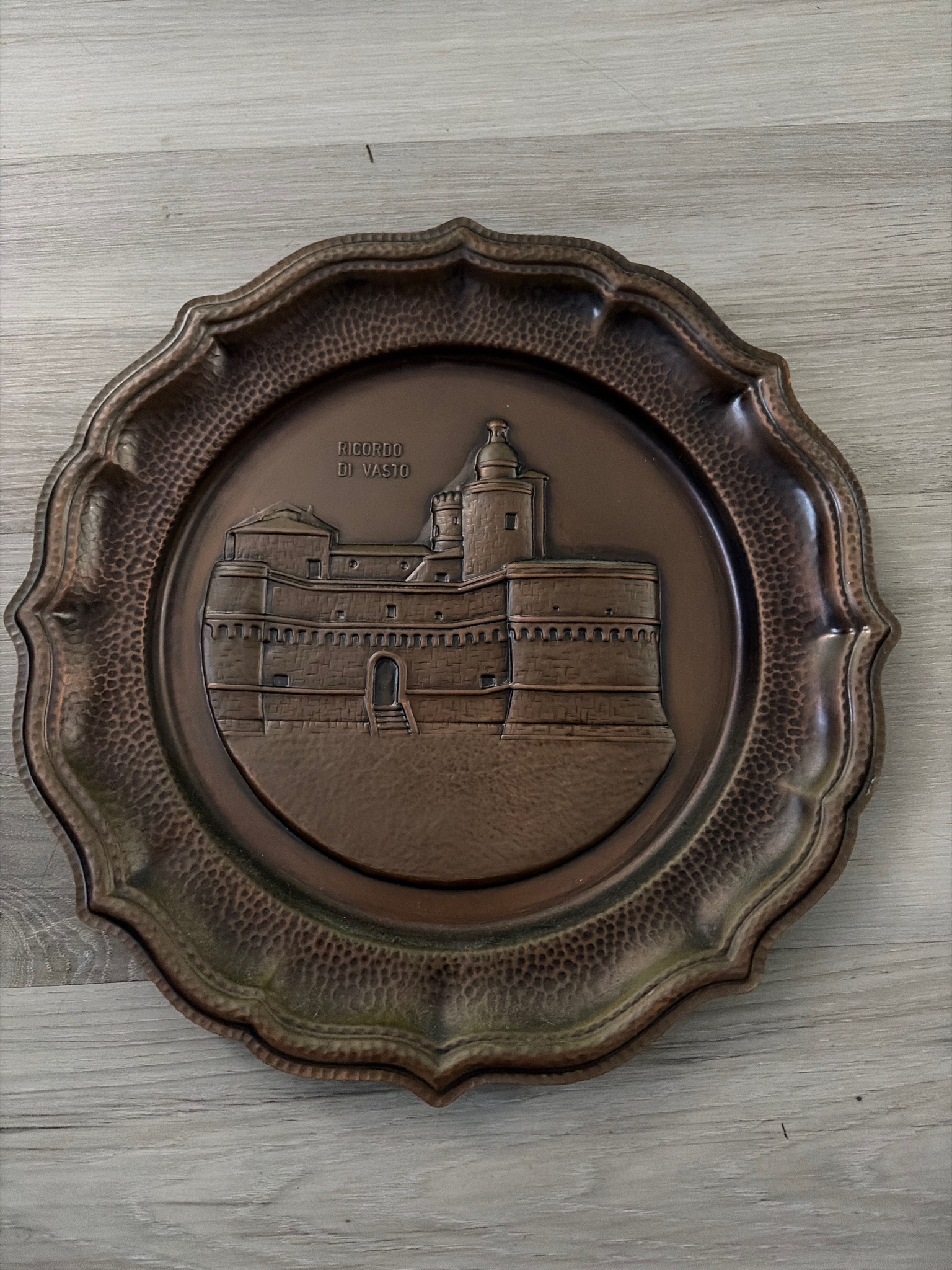 Submitted photo of Repoussé copper decorative wall plate featuring a castle relief