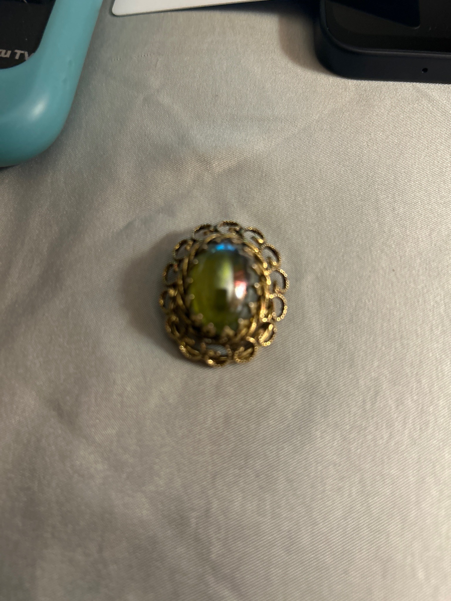 Submitted photo of Vintage filigree brooch with central iridescent art glass cabochon