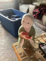 Child Figurine Holding a Red Fish