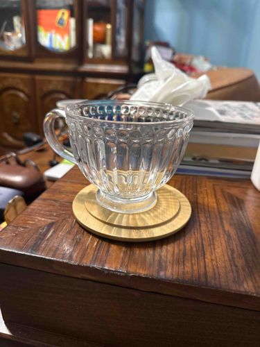 Pressed Glass Teacup with Ribbed and Hobnail Design on Wooden Coaster