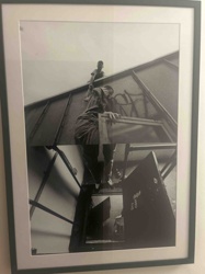 Black and White Framed Photograph of Figures on a Rooftop and in a Stairwell