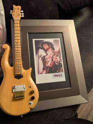 Prince-Themed Display with Miniature Guitar and Framed Photo