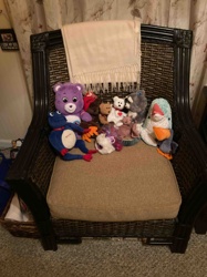 Dark Brown Wicker Armchair with Beige Cushion and Assorted Plush Toys