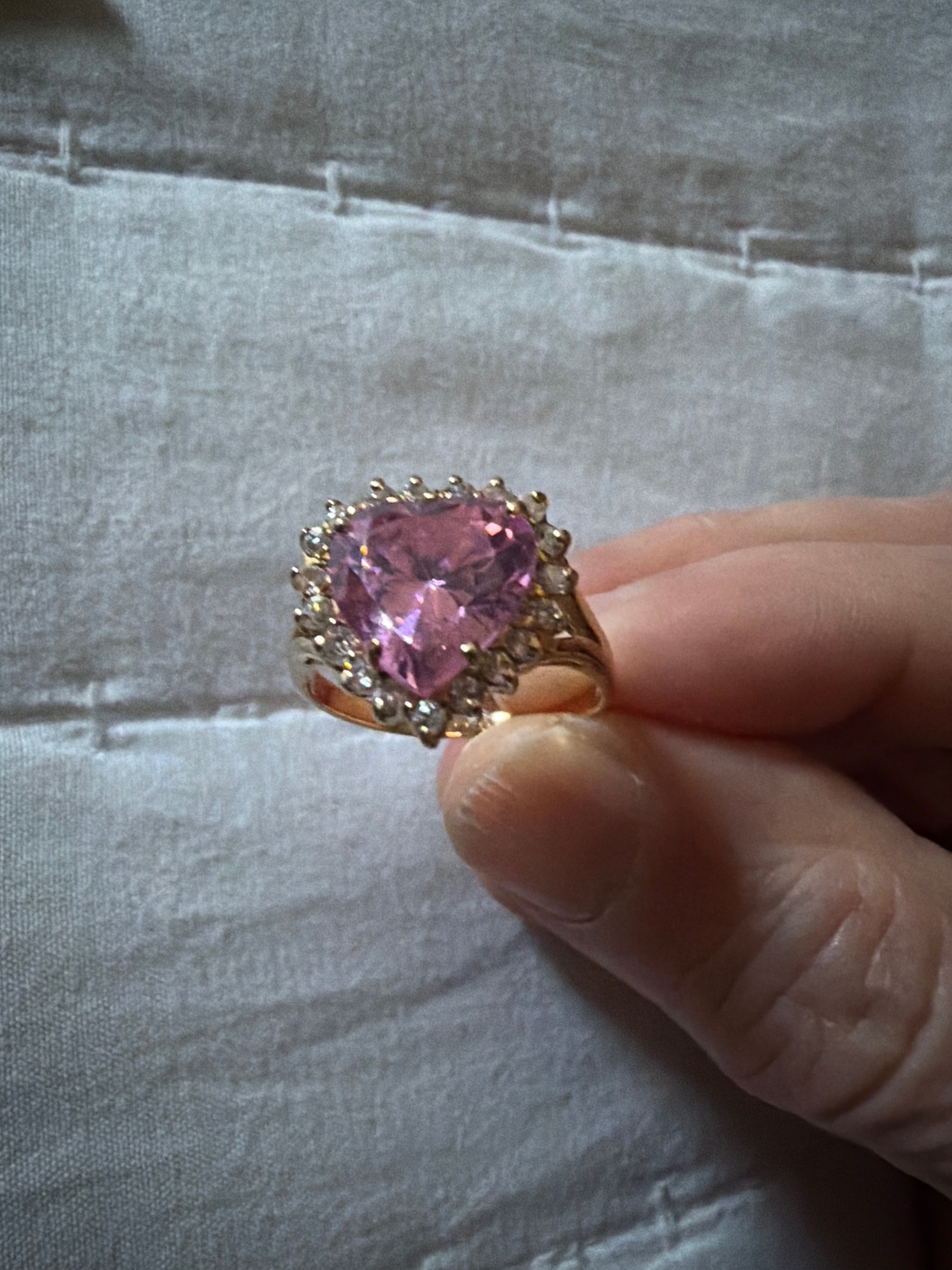 Submitted photo of Gold-toned ring with a heart-cut pink gemstone and halo setting