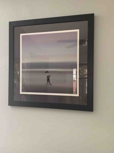 Framed Photograph: Couple with Umbrella on a Seashore