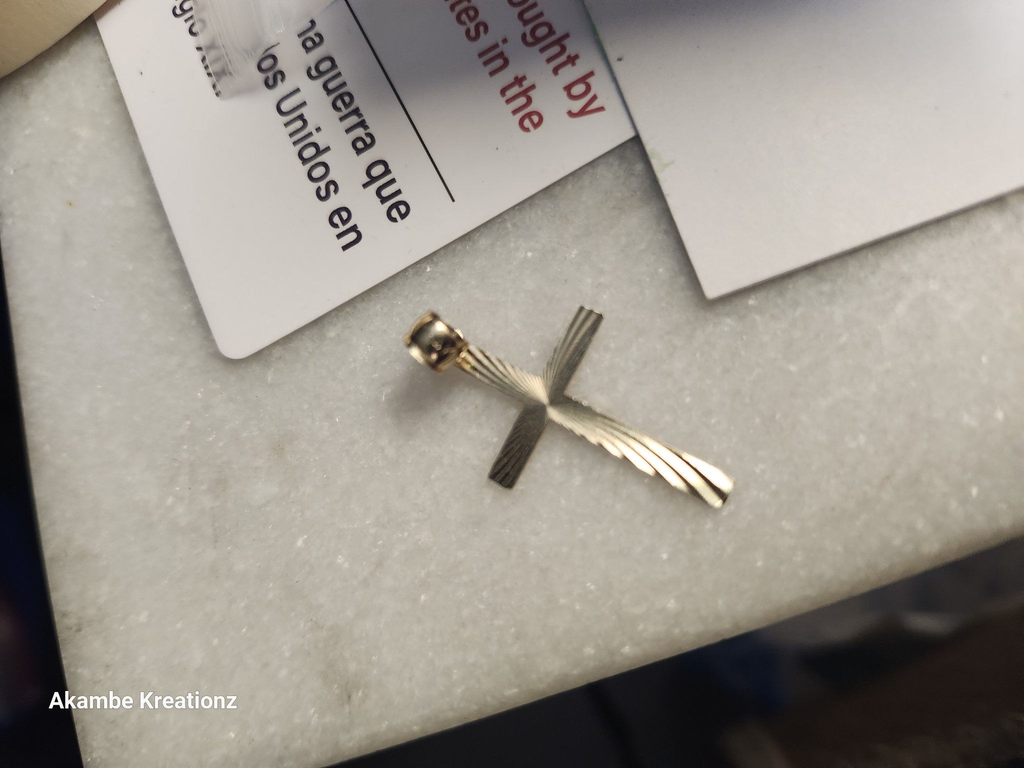 Submitted photo of Gold-toned cross pendant with textured ray pattern