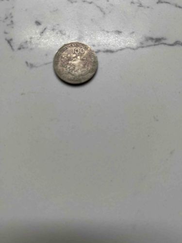 Silver-colored Coin with '100' and Eagle Motif (Obverse)