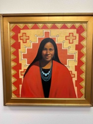 Portrait of a Native American Woman in Red Shawl with Turquoise Necklace Against a Textile Backdrop
