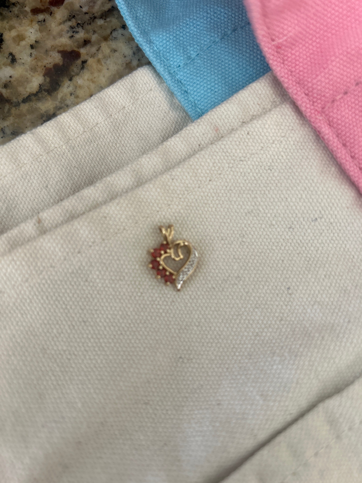 Submitted photo of Gold-tone heart pendant with red gemstones and pavé accents