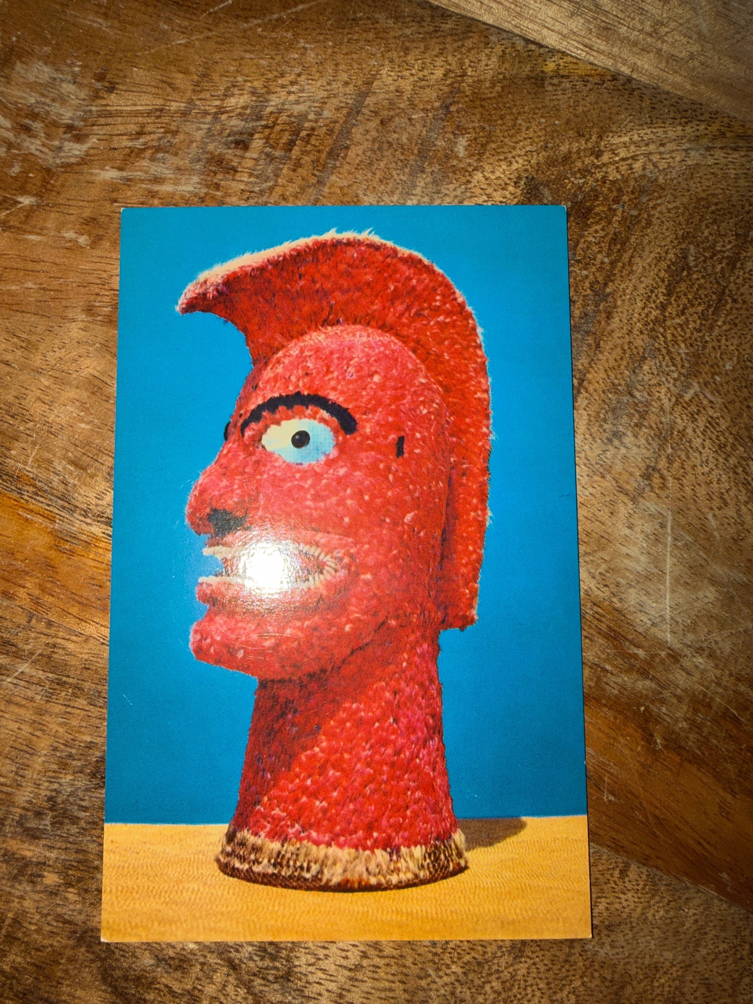 Submitted photo of Printed postcard depicting a red textured sculptural head