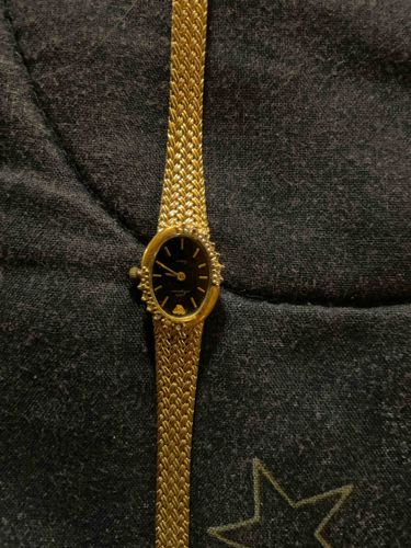 Oval-faced Ladies' Gold-Tone Dress Watch with Gemstone Bezel