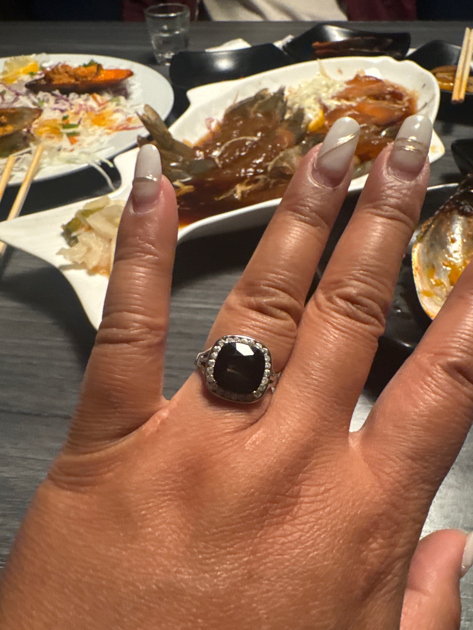 Submitted photo of White gold ring with dark gemstone and diamond halo (unauthenticated)
