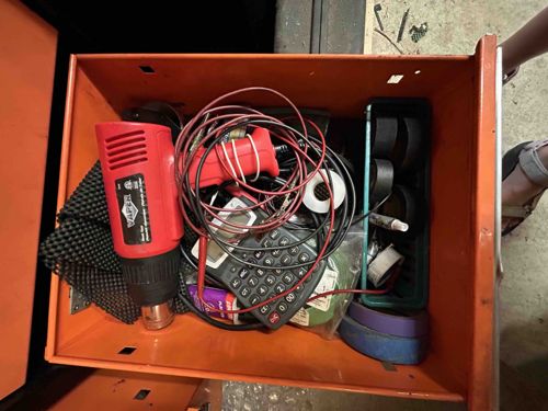 Assorted Tools and Electronic Components in an Orange Toolbox Drawer