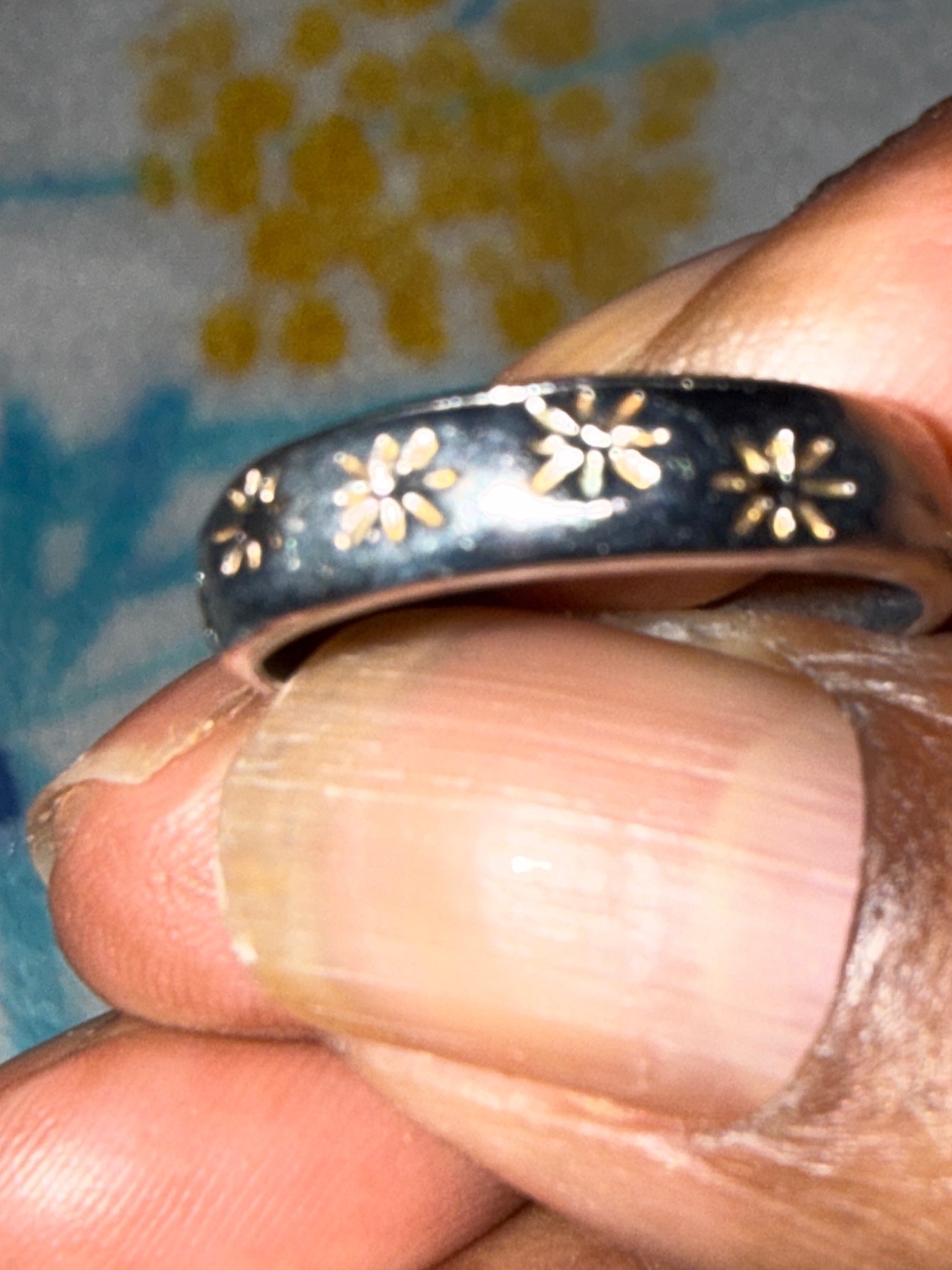 Submitted photo of Silver-tone metal band ring with inlaid star or flower motifs