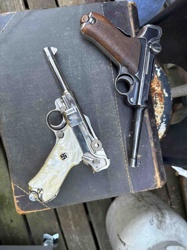 Pair of German Luger P08 Pistols, one with blued finish and wood grips, the other with bright metal finish and custom "Mother-of-Pearl" style grips with swastika emblem