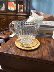 Pressed Glass Teacup with Ribbed and Hobnail Design on Wooden Coaster