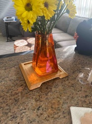 Orange Glass Vase with Bamboo Tray Holding Yellow Mums