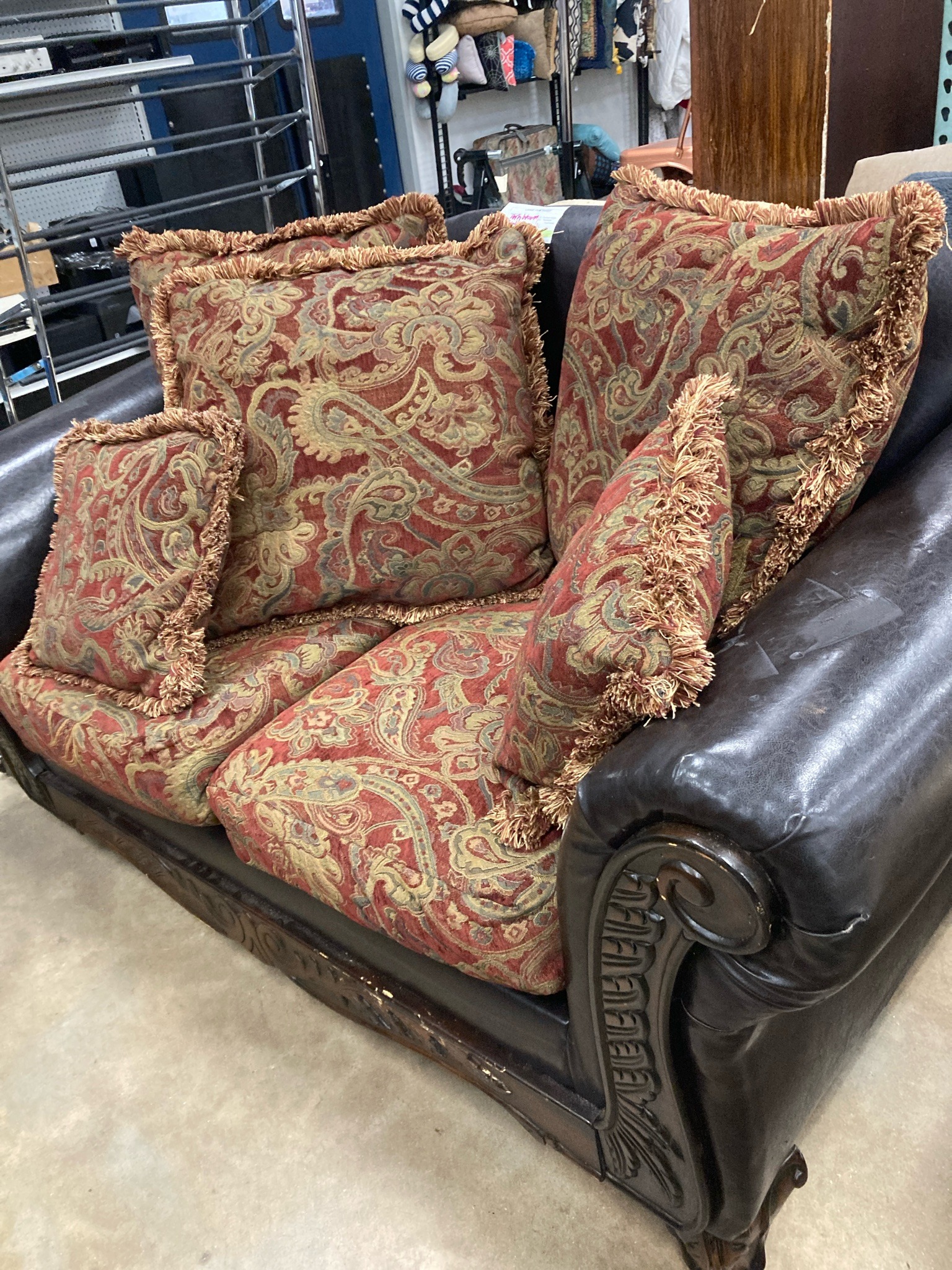 Submitted photo of Tufted loveseat with carved wood frame and patterned cushions
